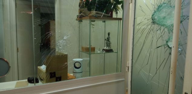 El vidre de l'establiment de compra-venda, destrossat a cops de maça. Foto: cedida