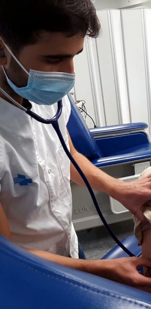 Un infermer auscultant una persona voluntària abans de l'administració de la vacuna contra la covid-19 d'Hipra, en el marc de la fase I/IIa de l'assaig clínic en humans.